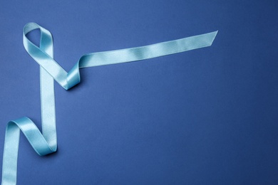 Light blue awareness ribbon on color background, top view with space for text. Symbol of social and medical issues