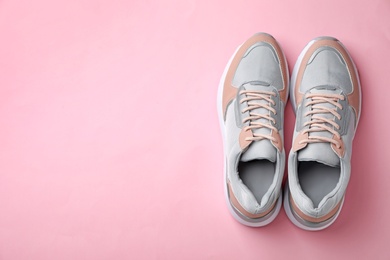 Pair of stylish sneakers on color background, top view. Space for text