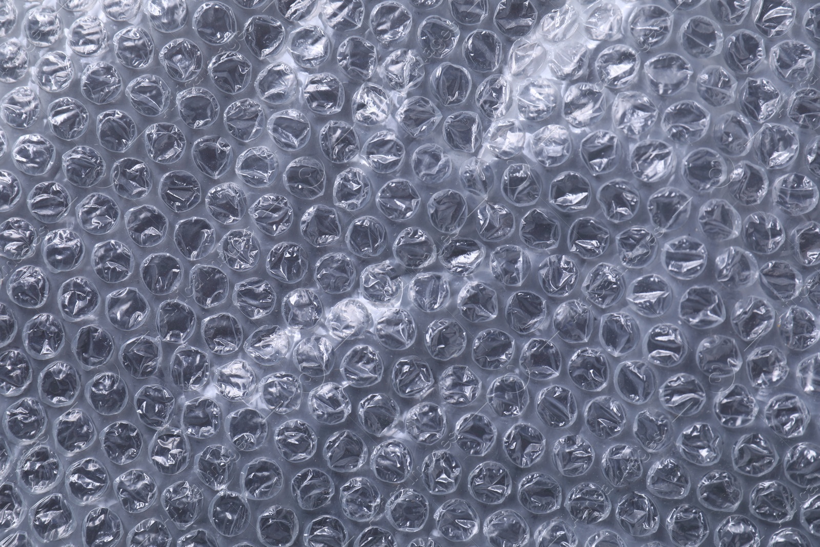 Photo of Transparent bubble wrap on black background, top view