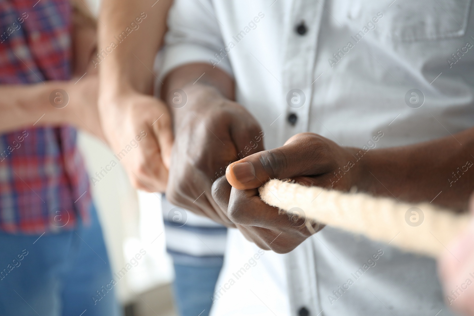 Photo of People pulling rope together, closeup of hands. Unity concept