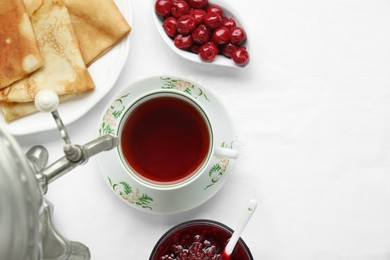 Cup of aromatic tea and treats on table, flat lay. Space for text