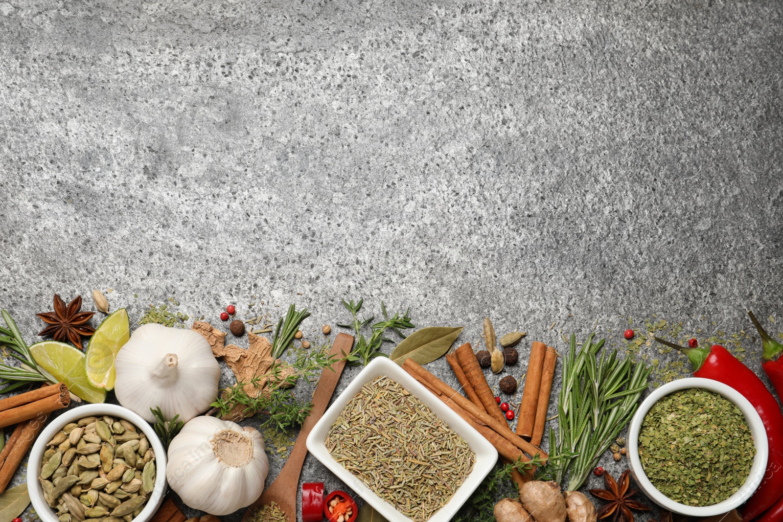 Photo of Flat lay composition with different natural spices and herbs on grey table, space for text