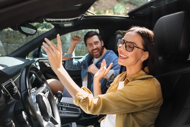 Happy couple enjoying trip together by car, selective focus