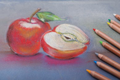 Photo of Beautiful drawing of apples and color pencils, closeup