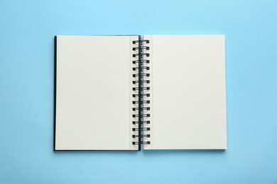 Photo of Open notebook on light blue background, top view