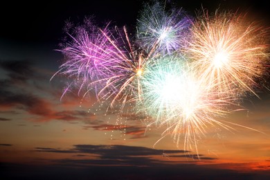 Image of Beautiful bright fireworks lighting up twilight sky outdoors