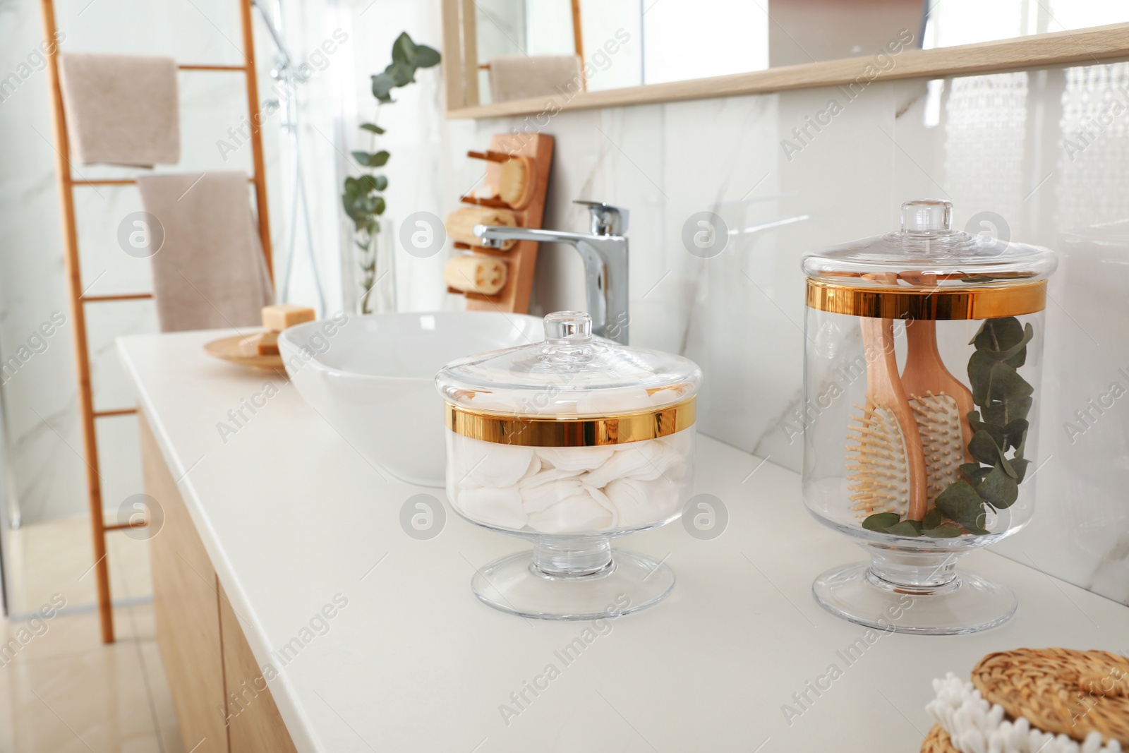 Photo of Jars with cotton pads and hairbrushes on bathroom countertop