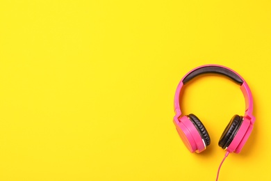 Stylish modern headphones on color background, top view. Space for text