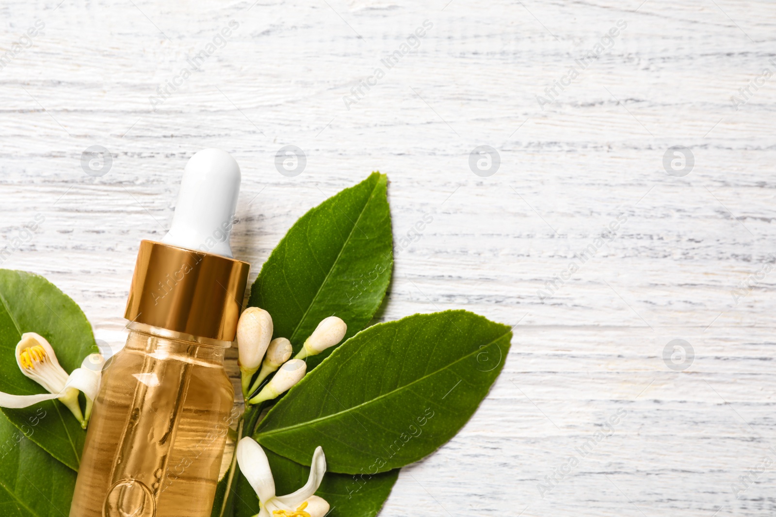 Photo of Flat lay composition with bottle of citrus essential oil on white wooden background. Space for text