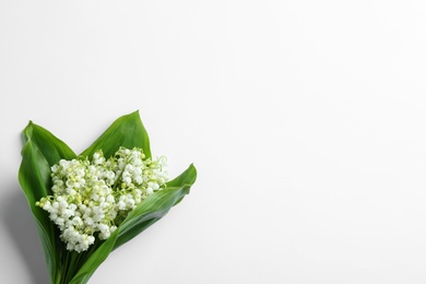 Photo of Beautiful lily of the valley bouquet on white background, view from above. Space for text