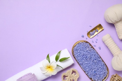 Beautiful spa composition with sea salt on violet background, flat lay. Space for text