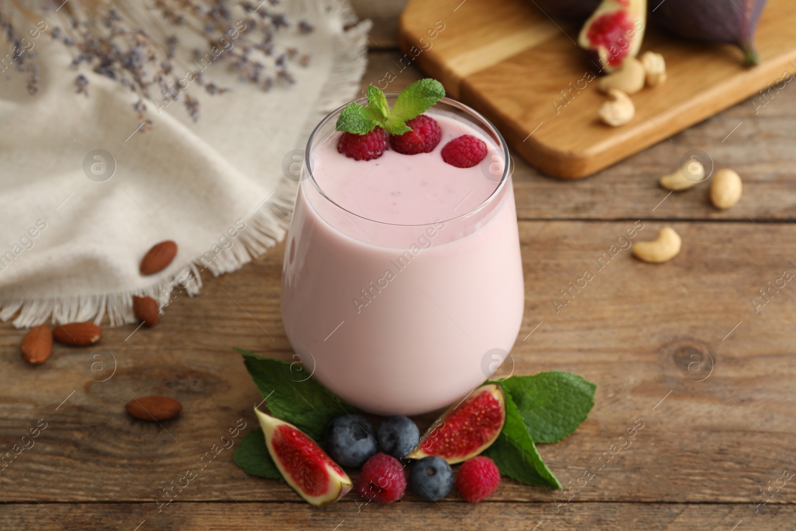 Photo of Delicious fig smoothie in glass on wooden table