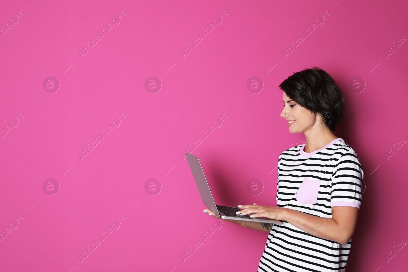 Photo of Young woman with modern laptop on color background