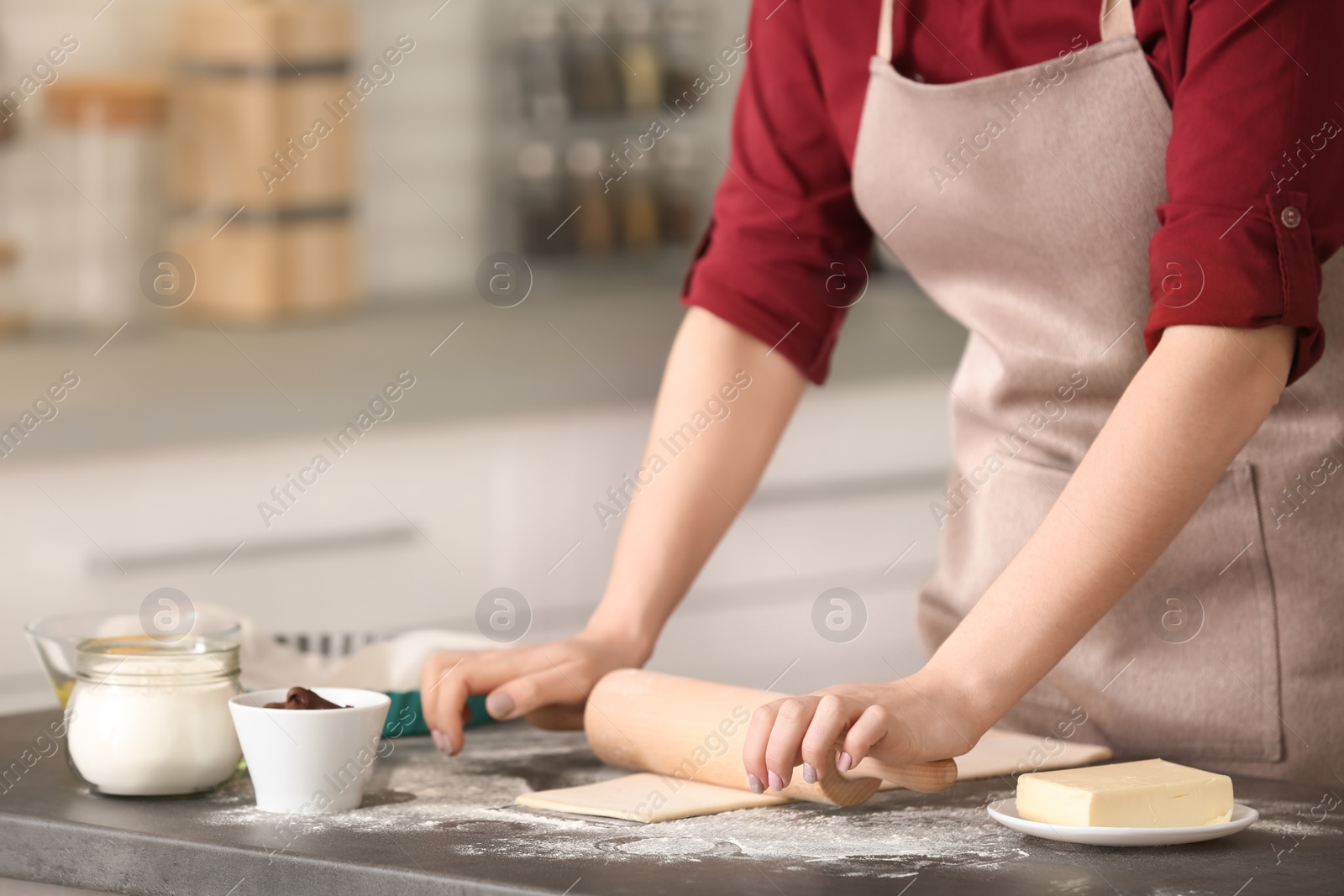 Photo of Woman preparing dough on table in kitchen, closeup