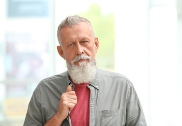 Photo of Portrait of handsome mature man against blurred background