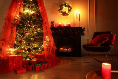 Photo of Beautifully wrapped gift boxes under Christmas tree near fireplace in living room