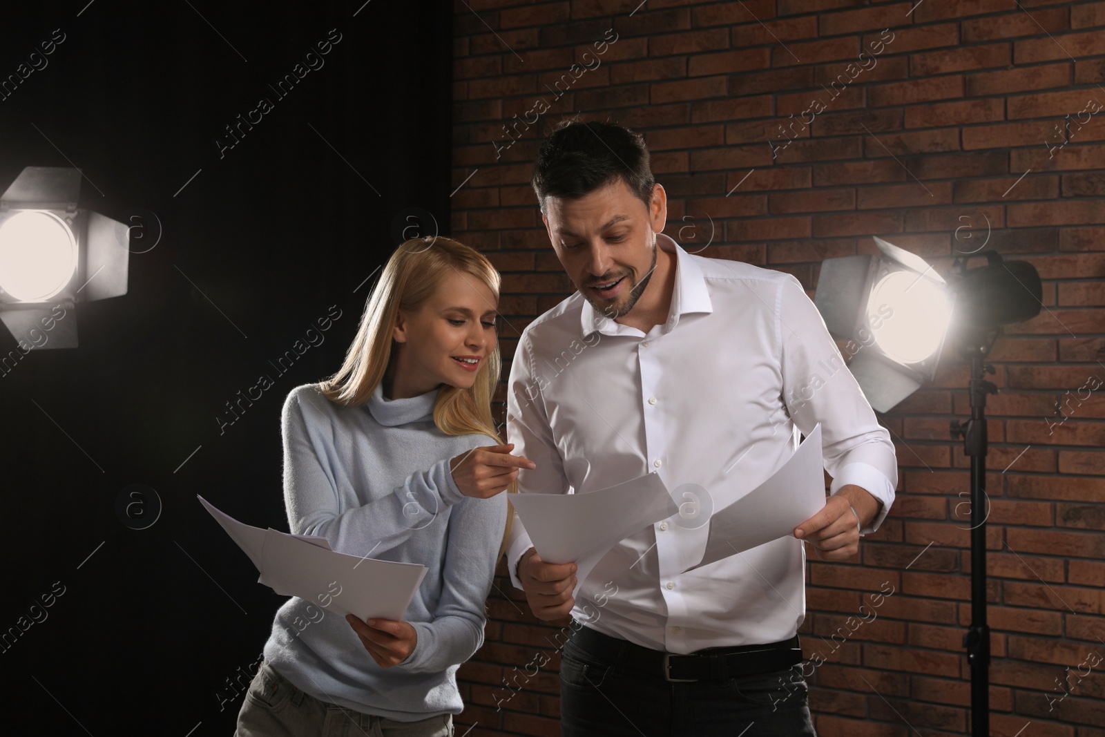 Photo of Professional actors reading their scripts during rehearsal in theatre