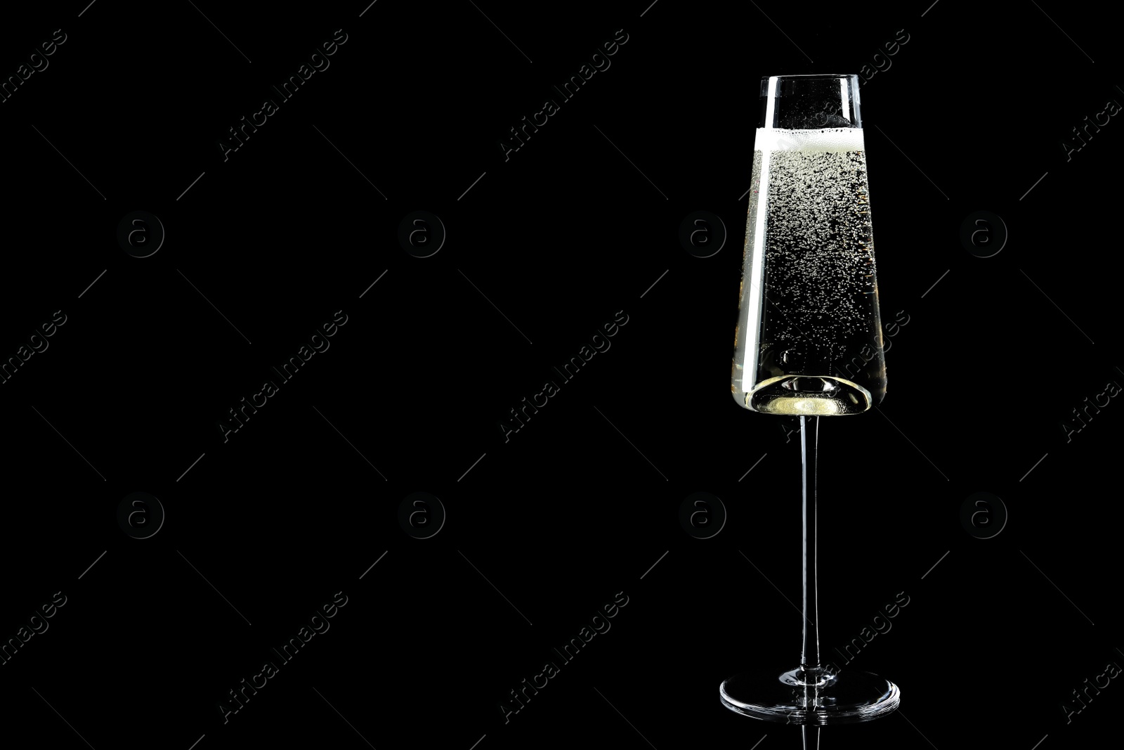 Photo of Glass of champagne on black background, space for text