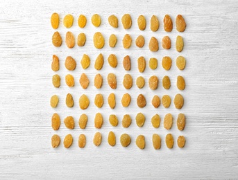 Flat lay composition with raisins on white wooden background. Dried fruit as healthy snack