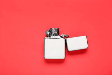 Photo of Gray metallic cigarette lighter on red background, top view