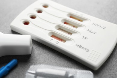 Disposable multi-infection express test kit on grey table, closeup