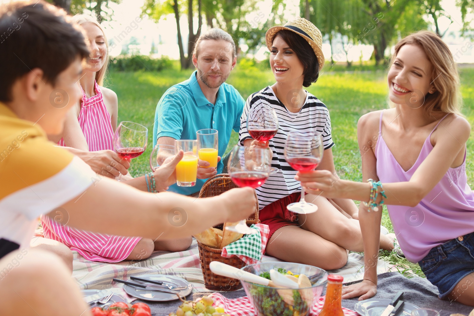 Photo of Happy friends having picnic in park on sunny day