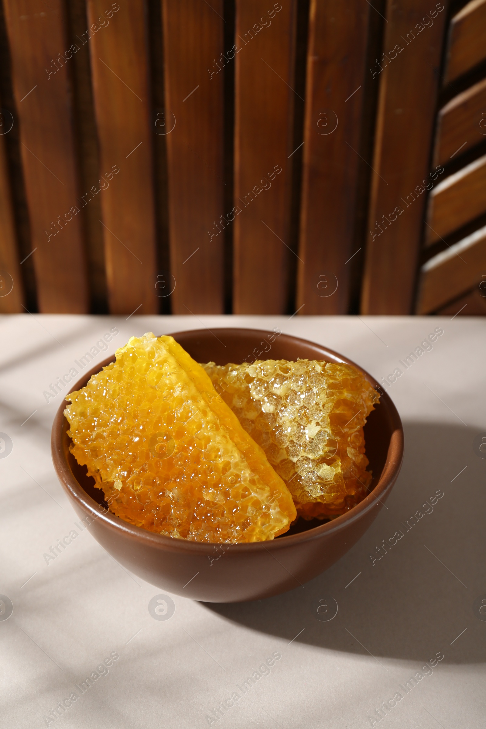 Photo of Natural honeycombs in bowl on white table