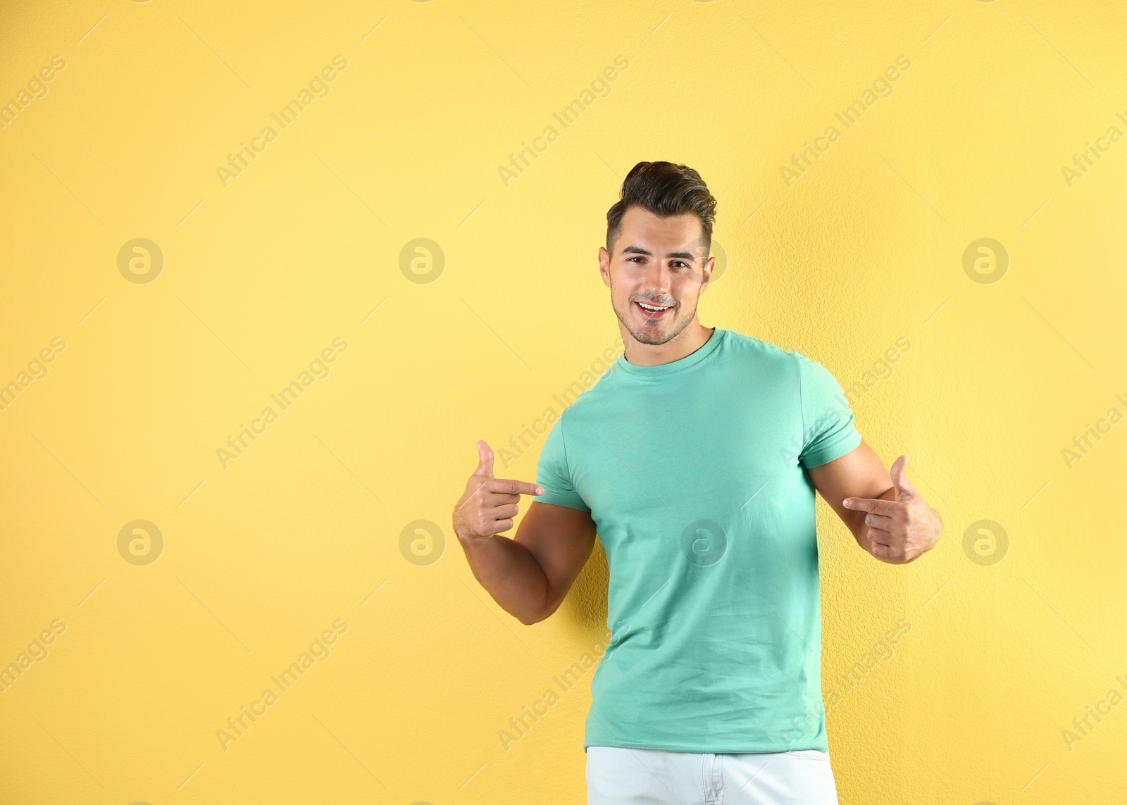 Photo of Young man in t-shirt on color background. Mockup for design