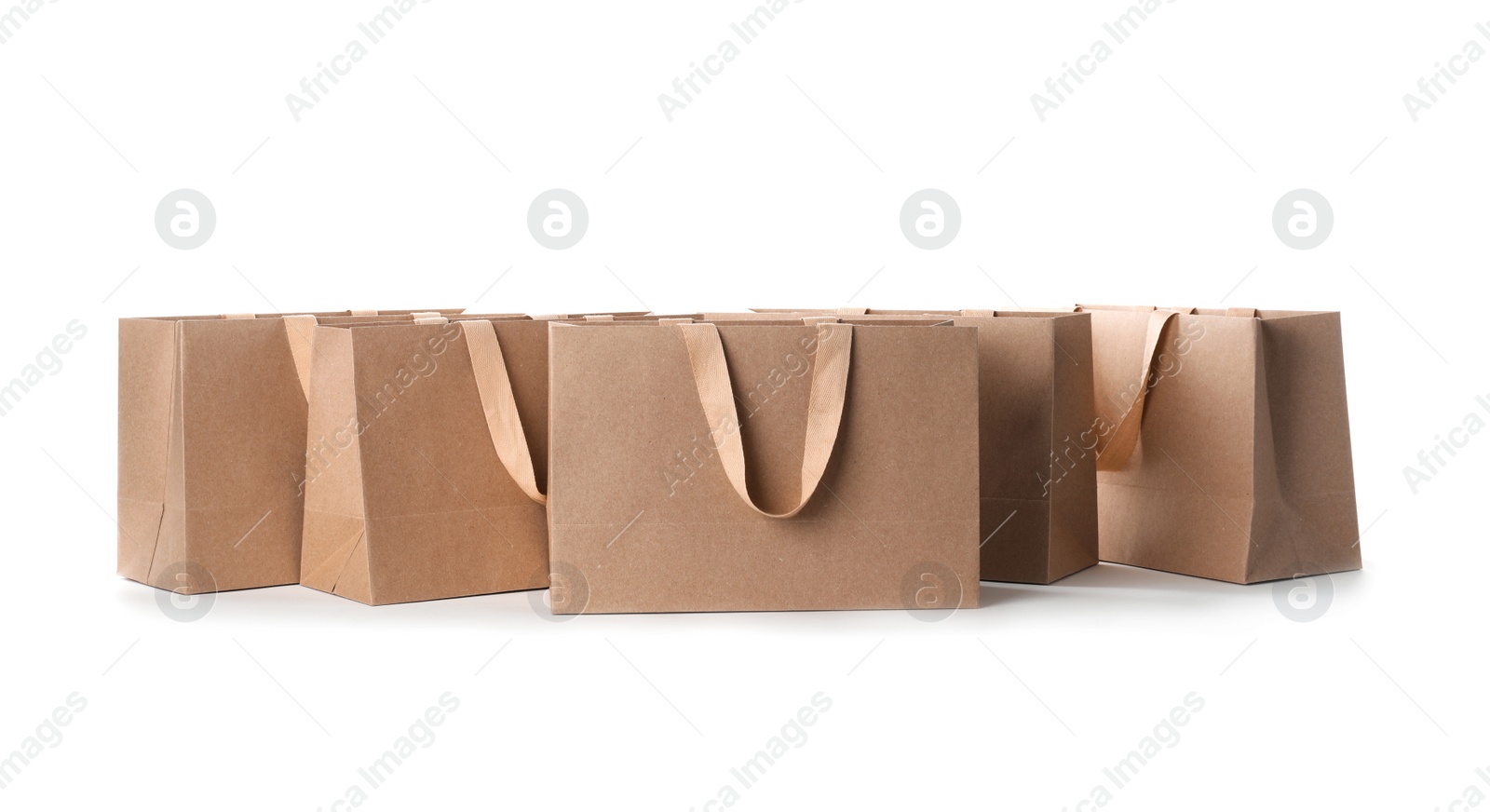 Photo of Paper shopping bags with comfortable handles on white background. Mockup for design