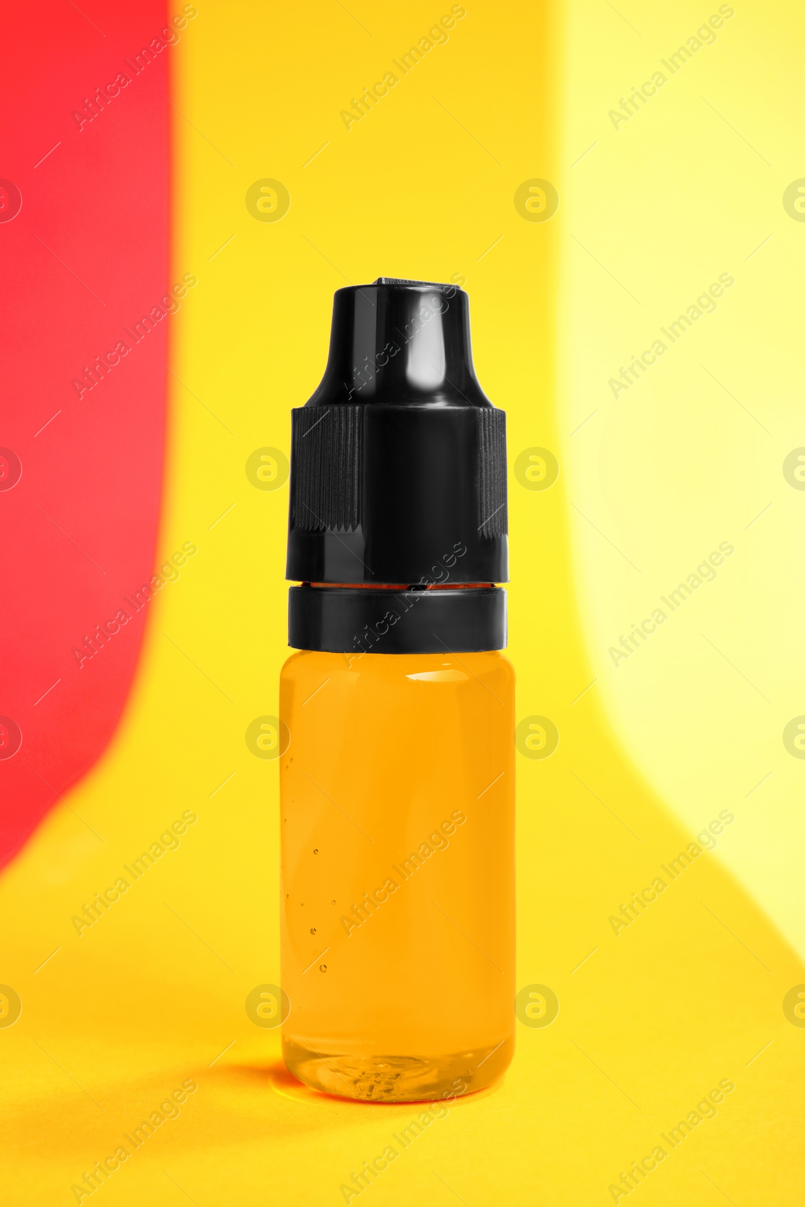 Photo of Bottle with orange food coloring on bright background