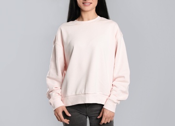 Young woman in sweater on grey background, closeup. Mock up for design