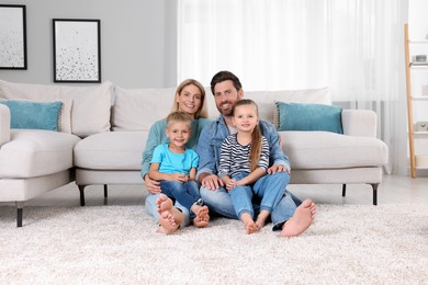 Photo of Portrait of happy family with children on soft carpet at home