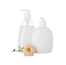 Photo of Dispensers of liquid soap and rose on white background
