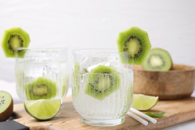 Photo of Refreshing drink, cut kiwi and lime on table