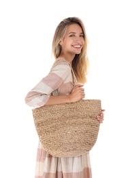 Beautiful young woman with stylish straw bag on white background