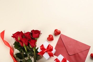 Photo of Flat lay composition with beautiful roses and gift boxes on light background, space for text. Valentine's Day celebration