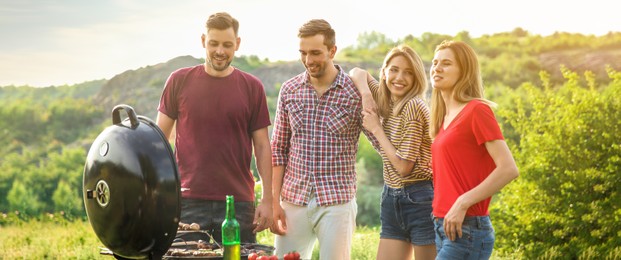 Image of Young people having barbecue outdoors. Banner design