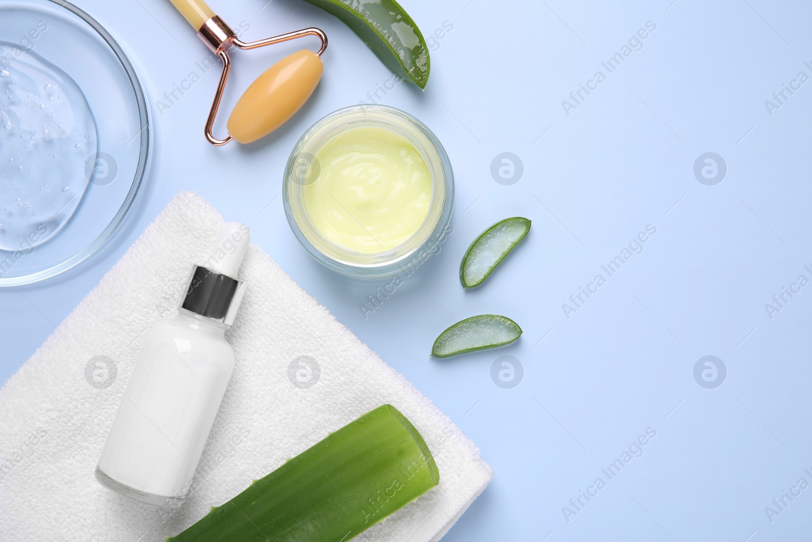 Photo of Flat lay composition with cosmetic products and cut aloe leaves on light blue background. Space for text