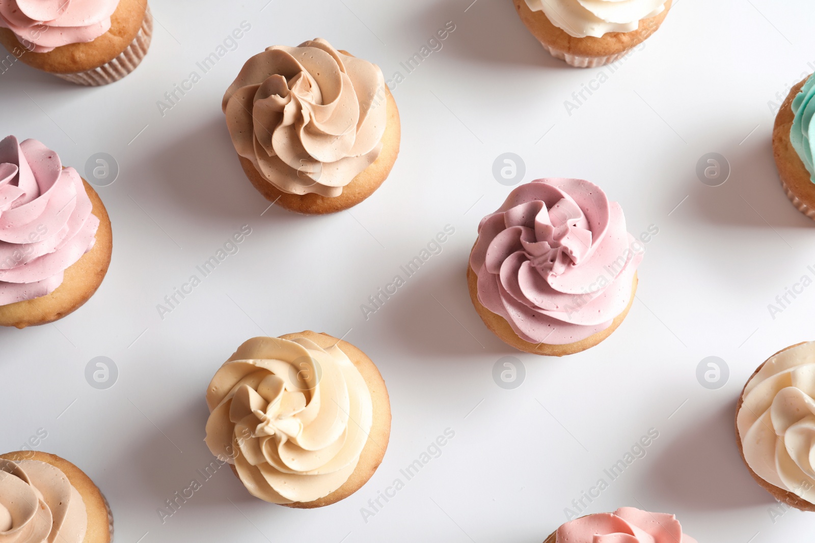 Photo of Flat lay composition with delicious birthday cupcakes on white background