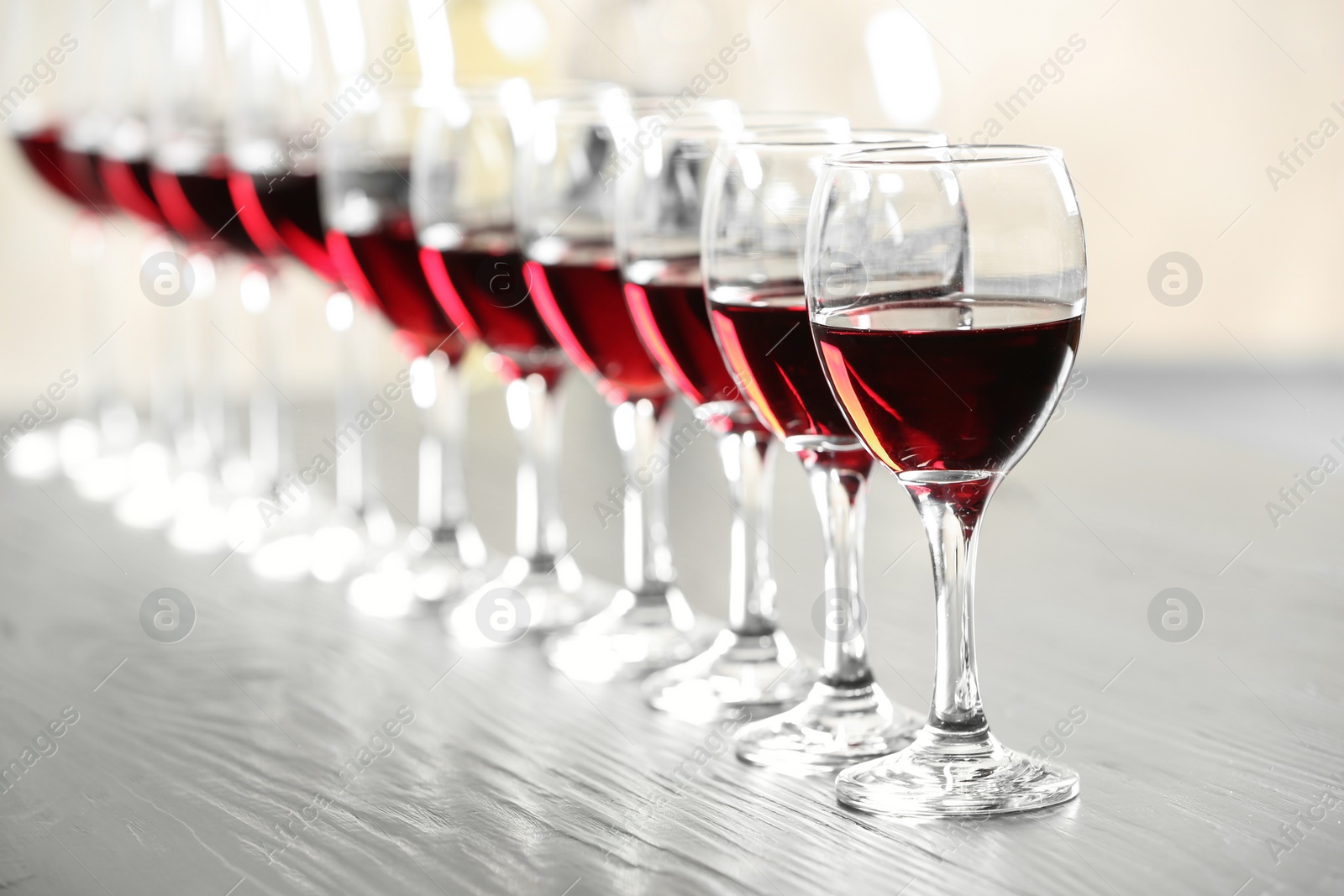 Photo of Glasses with delicious red wine on table