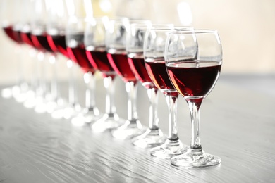 Photo of Glasses with delicious red wine on table