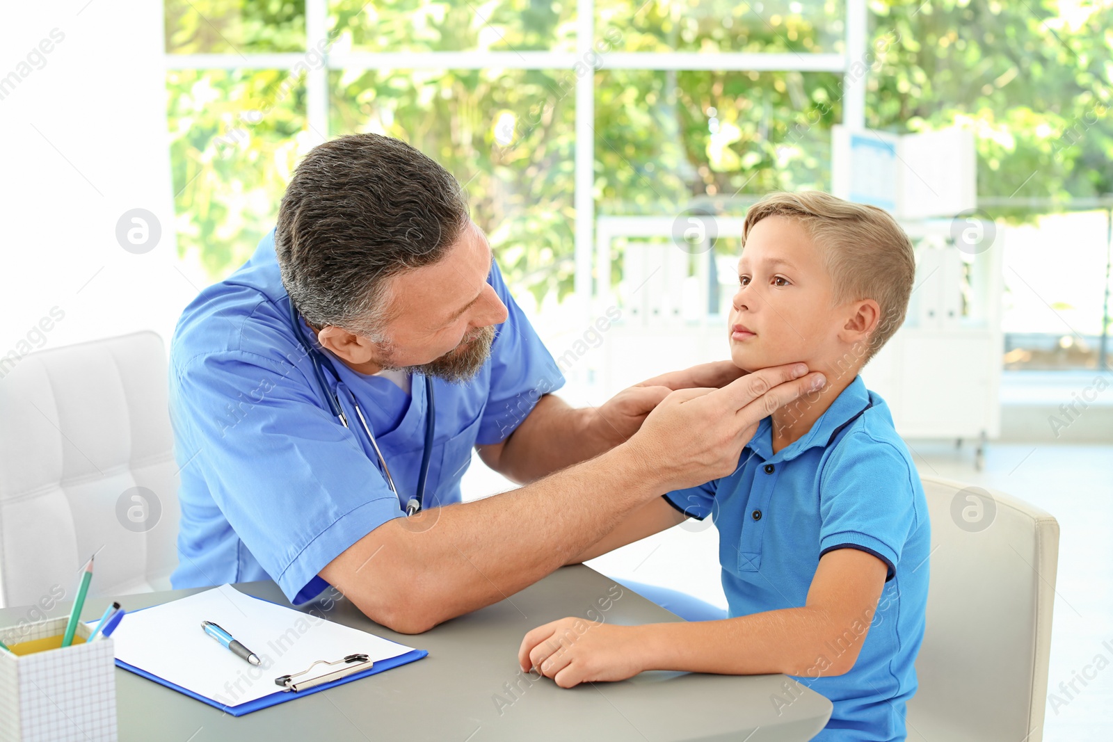 Photo of Male medical assistant examining child in clinic