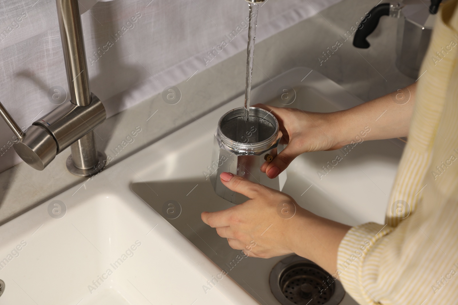 Photo of Woman washing moka pot at sink in kitchen, closeup