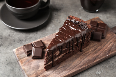 Photo of Piece of delicious chocolate cake on grey table