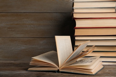 Photo of Stack of hardcover books on wooden table. Space for text