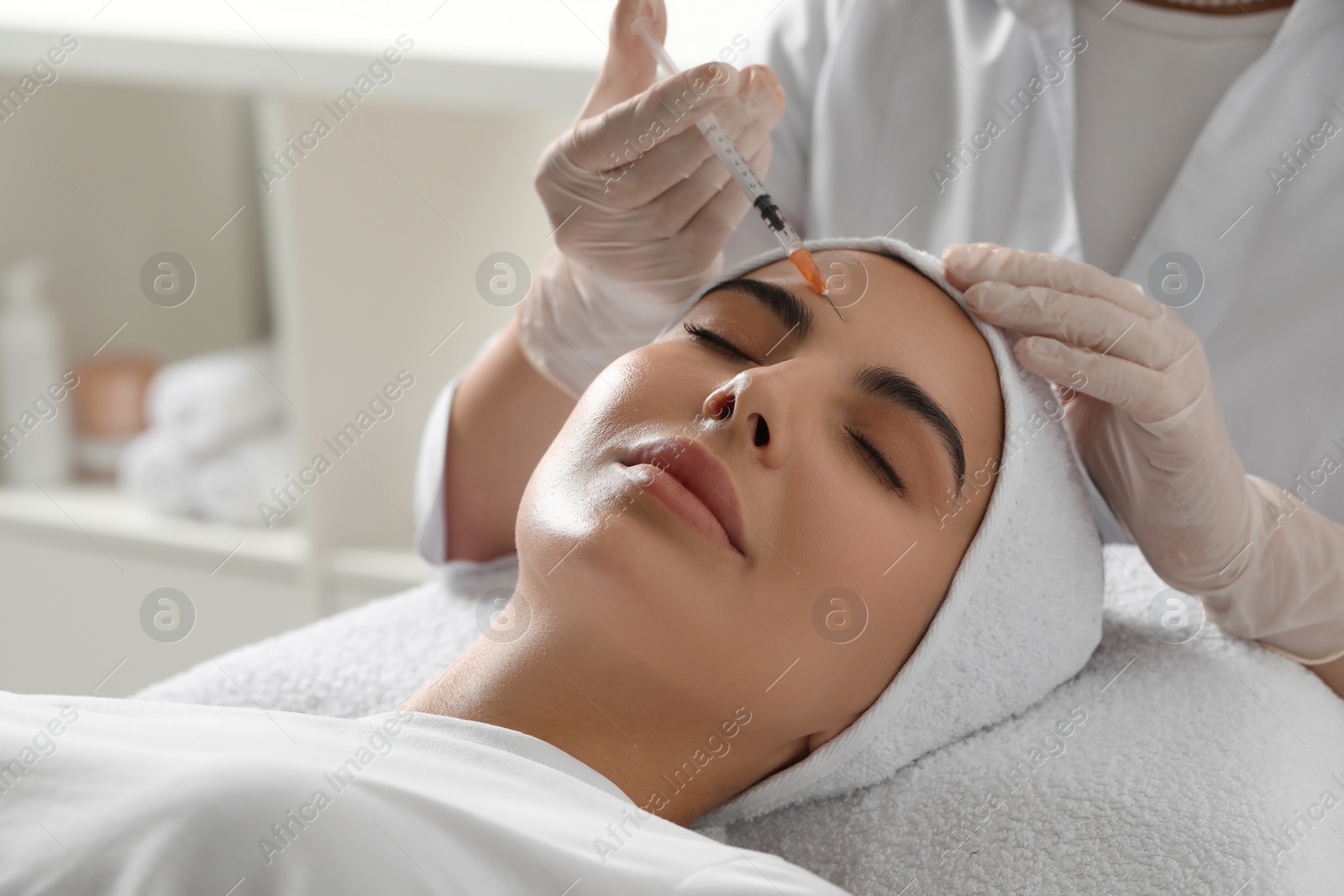 Photo of Doctor giving facial injection to young woman in clinic. Cosmetic surgery