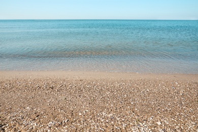 Photo of Beautiful view of sandy beach and sea on sunny summer day