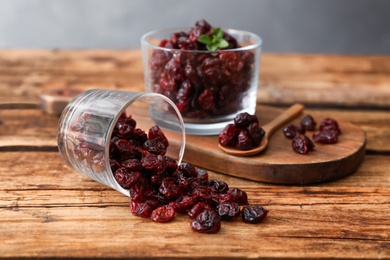 Composition with tasty dried cranberries on wooden table