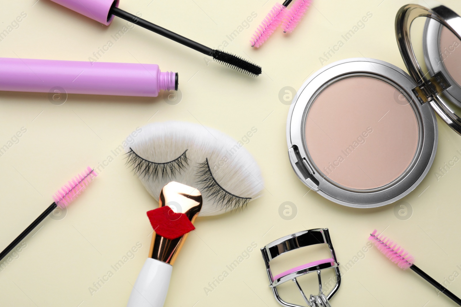 Photo of Flat lay composition with false eyelashes on beige background