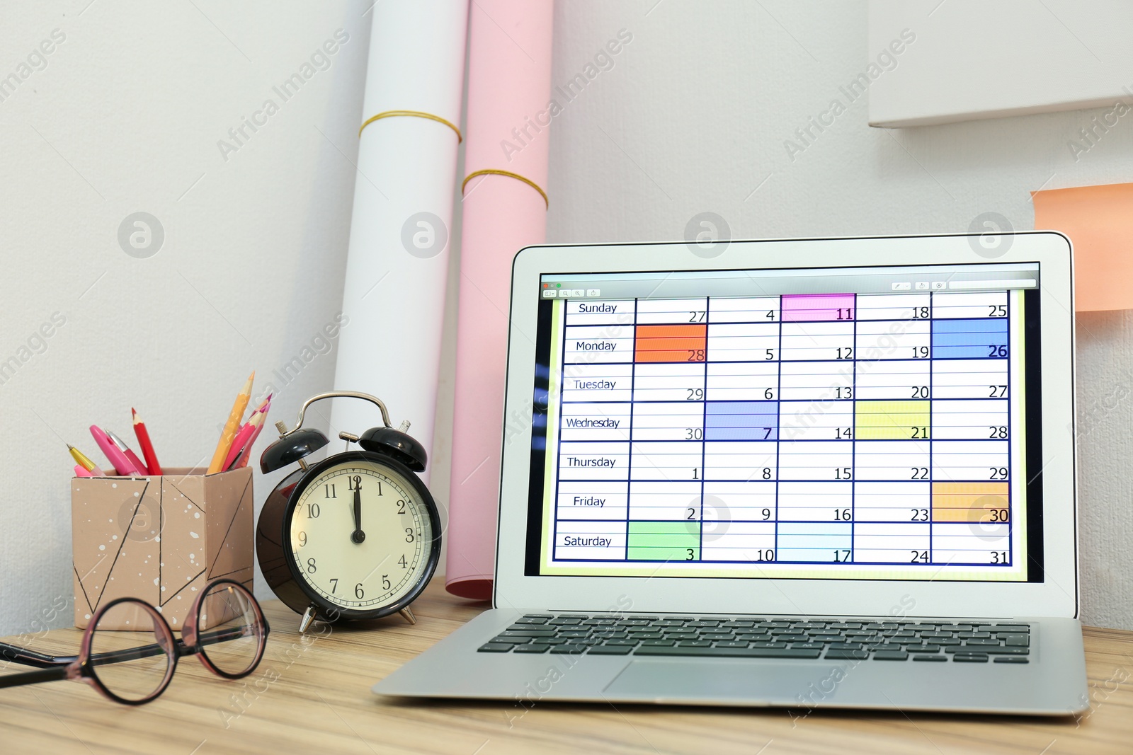 Photo of Modern laptop with calendar on screen in office